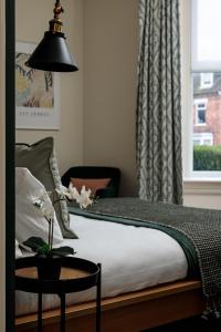 a bedroom with a bed with a table and a window at Brayford House in Lincoln