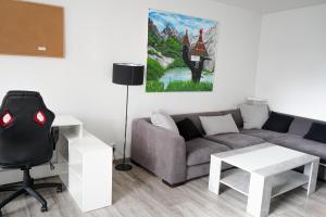 uma sala de estar com um sofá, uma secretária e um quadro em Apartmán u Martina em Žilina
