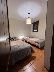 Habitación con 2 camas y puerta abierta en Acogedor y Céntrico Apartamento en Mora de Rubielos