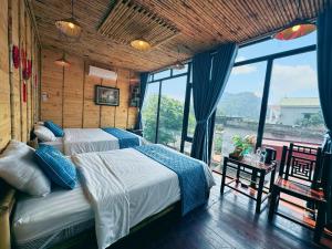 a bedroom with two beds and a large window at Trang An Moon Garden Homestay in Ninh Binh