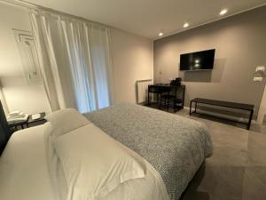 1 dormitorio con 1 cama blanca y TV en Alla Casa Di Giò en Milán