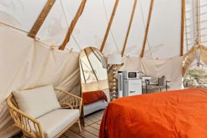 a room with a bed and a chair in a tent at Furnished Teepee/Glamping/Red River Access/King Bd in Stanton