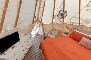 a bedroom with a bed and a tv in a tent at Furnished Teepee/Glamping/Red River Access/King Bd in Stanton
