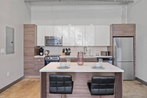 a kitchen with a large island with two chairs at Luxurious Downtown Apt - Pool, Laundry, Parking in Dallas