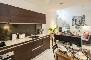 a kitchen with wooden cabinets and a table with plates on it at Central-family-convenient-soho in London
