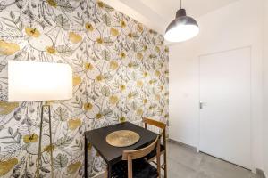 une salle à manger avec une table et un papier peint à fleurs dans l'établissement Nouveau studio tout équipé Charbonnières les Bains, à Charbonnières-les-Bains