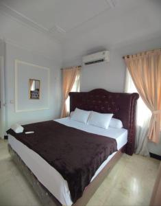 ein Schlafzimmer mit einem großen Bett mit einer schwarzen Decke in der Unterkunft Vila Princess,Sentul 4br, private pool, tenis meja, mini billiard, Home theater Karaoke, Ayunan besar,BBQ, 08satu3 80satu6 4satu5satu in Bogor