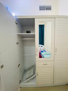 Habitación con armario blanco y cama. en Serene Nest, en Umm Al Quwain