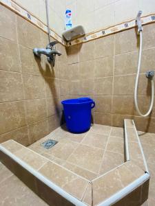 a bathroom with a bucket on a tiled floor at Serene Nest in Umm Al Quwain