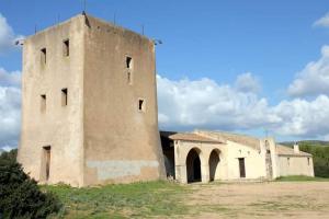 Ein altes Gebäude auf einem Feld mit einem Himmel in der Unterkunft Casa vacanza Il Podere in Teulada