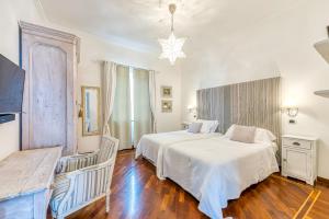 1 dormitorio con cama blanca y lámpara de araña en Villa Miragalli, en Sant'Agnello