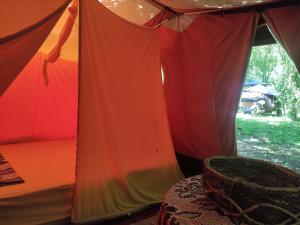 an orange and red tent with a table in front at Different Belgrade camping in Vrčin