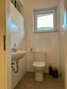 City Living Bischofshofen - Premium Stadtwohnung في بيشوفشوفن: حمام مع مرحاض ومغسلة ونافذة