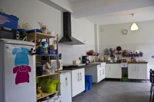 uma cozinha com armários brancos e um frigorífico em Fontaineblhostel hostel & camping near Fontainebleau em La Chapelle-la-Reine