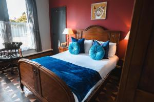 a bedroom with a large bed with blue pillows at The Godwins in Hereford