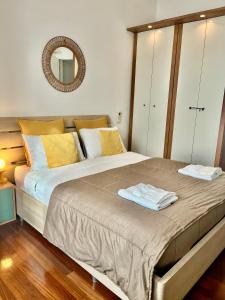 ein Schlafzimmer mit einem Bett mit gelben Kissen und einem Spiegel in der Unterkunft MilanoView Apartment in Mailand