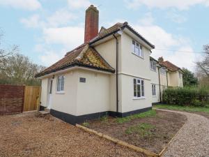 a white house with a brick fence at 3 Chantry Cottages in Woodbridge