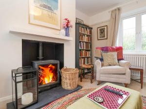 a living room with a wood stove in a fireplace at 3 Chantry Cottages in Woodbridge