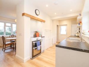 a kitchen with a sink and a stove top oven at 3 Chantry Cottages in Woodbridge