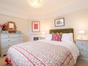 a bedroom with a bed and a dresser at 3 Chantry Cottages in Woodbridge