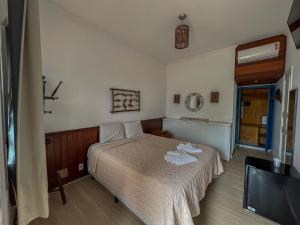 um quarto com uma cama e uma televisão de ecrã plano em Hotel Porto do Eixo Ubatuba em Ubatuba