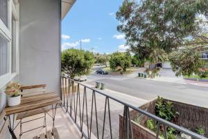 a balcony with a bench and a view of a street at TheWest36 - Sandy Escape in Henley Beach South