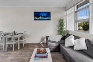 a living room with a couch and a table at TheWest36 - Sandy Escape in Henley Beach South