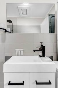 a white bathroom with a sink and a mirror at TheWest36 - Sandy Escape in Henley Beach South