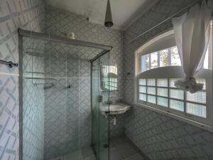 a bathroom with a shower and a sink at Hotel Porto do Eixo Ubatuba in Ubatuba