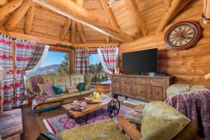a living room with a television in a cabin at Rustic villa Roza with outdoor pool in Kupjak in Kupjak