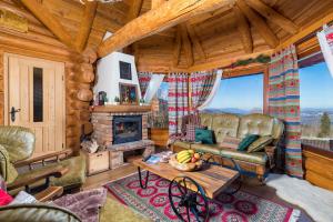a living room with a fireplace in a log cabin at Rustic villa Roza with outdoor pool in Kupjak in Kupjak