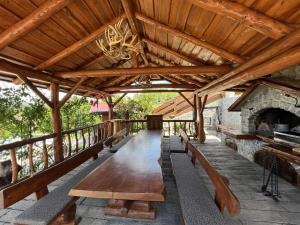 un patio al aire libre con mesa de madera y chimenea en Rustic villa Roza with outdoor pool in Kupjak, en Kupjak