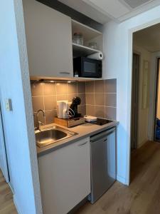 a small kitchen with a sink and a microwave at Appart'Hotel - Gare TGV - Courtine - Confluence - 218 in Avignon