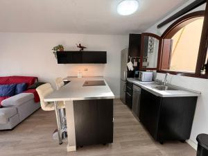 a kitchen and living room with a sink and a couch at Alquilaencanarias Tagoro Paradise in Costa Del Silencio