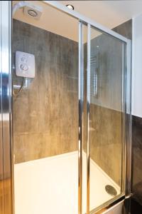 a shower with a glass door in a bathroom at Modern Studio Oasis in the Heart of the City in Brighton & Hove