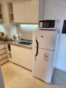 a white refrigerator with a microwave on top of it at Costanera Vista Edificio Alarif Trench in Posadas