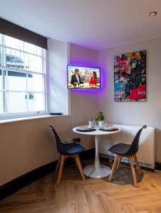 a room with a table and two chairs and a tv at Modern Studio Oasis in the Heart of the City in Brighton & Hove