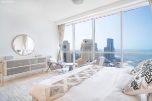 a large white bedroom with a large window at Gardenia Al Fattan Marine Suites - Luxury Apartments in JBR with Full Sea View and only 2m walk to Beach in Dubai