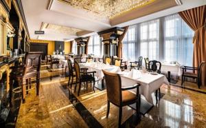 een restaurant met witte tafels, stoelen en ramen bij Hanza Tower Hotel 5 Stars in Szczecin
