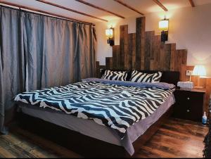 a bed in a bedroom with a zebra print blanket at Hills&MING B&B in Shanghai