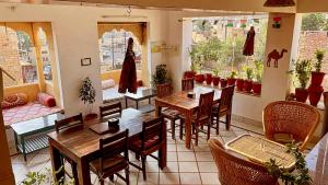 Un restaurante con mesas y sillas en una habitación. en The Wanderlust Guest House & Safari, en Jaisalmer