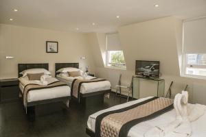 a hotel room with two beds and a television at NOX Notting Hill in London