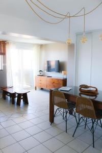 - un salon avec une table, des chaises et une télévision dans l'établissement Résidence Lou Cout, à Vieux-Boucau-les-Bains