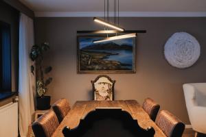 a dining room with a wooden table and chairs at Botnahlid Villa in Seyðisfjörður