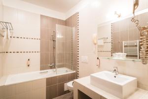 a bathroom with a sink and a tub and a toilet at Hotel Turiec in Martin