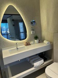 y baño con lavabo y espejo. en Allenbeach TLV- apart Hotel- Adults only, en Tel Aviv