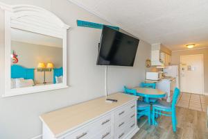 Zimmer mit einem Schlafzimmer mit einem Schreibtisch und einem TV in der Unterkunft Sea Mist 51405 in Myrtle Beach