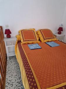 ein Schlafzimmer mit einem Bett mit zwei Kissen darauf in der Unterkunft Gîte Le Val des Fées classés deux étoiles in Roussillon