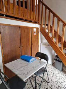 einen Tisch und einen Stuhl in einem Zimmer mit einer Treppe in der Unterkunft Gîte Le Val des Fées classés deux étoiles in Roussillon