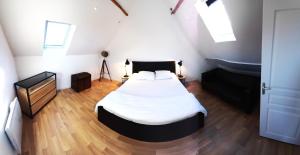 a bedroom with a bed and a wooden floor at La Paillote relais du Chatô n3 in Quend